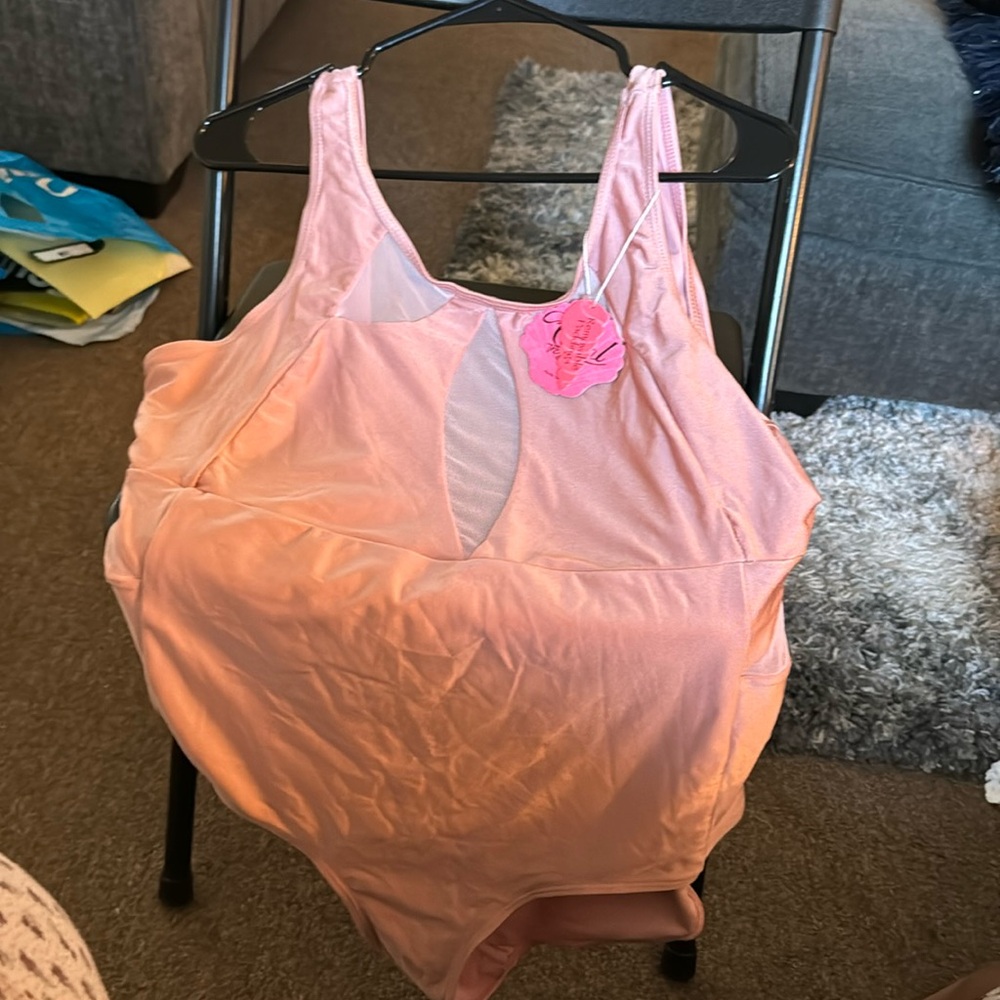 Dusty rose colored swim suit with sheer inserts on top and sides. Low back